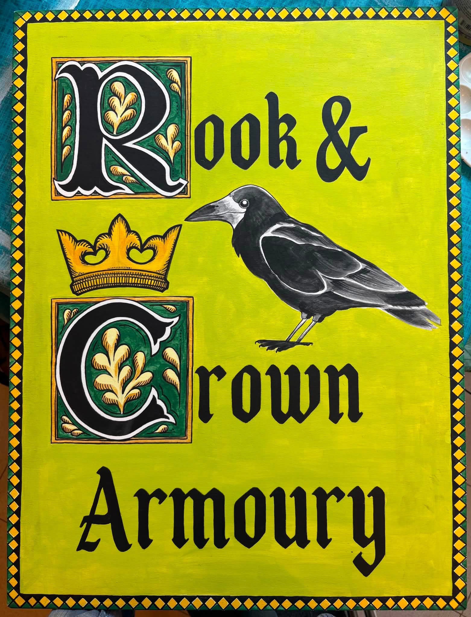 Hand-painted Rook & Crown Armory sign with illuminated-style lettering, crown, and raven