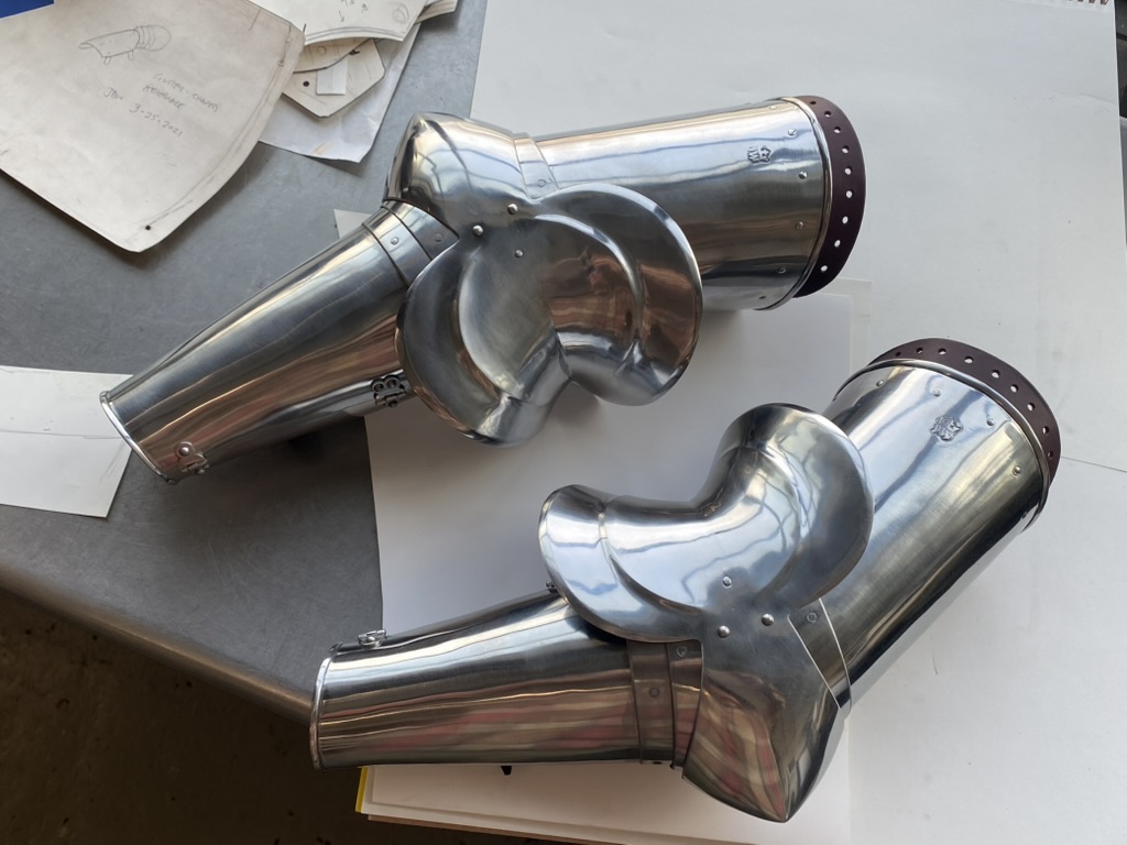Polished steel articulated armor components arranged on a tabletop