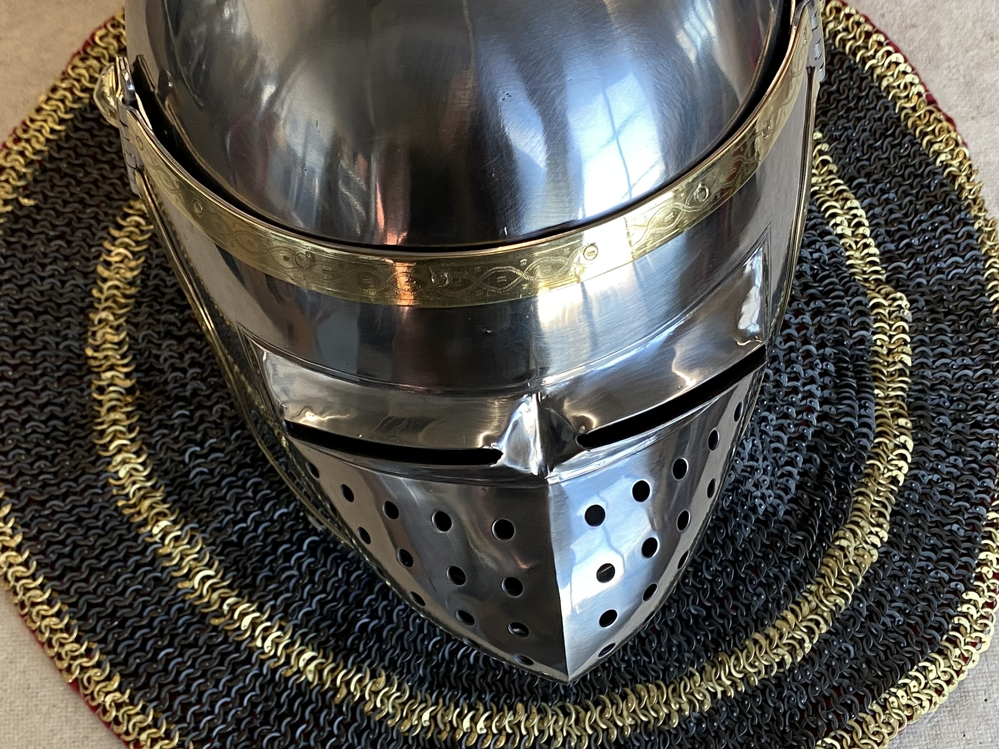 Close view of polished custom medieval helmet with engraved brass band